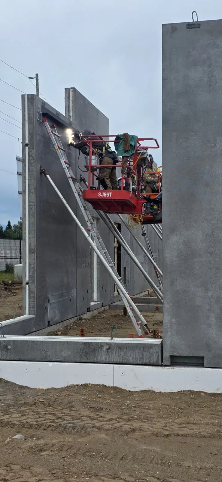 Crew working between concrete wall panels at the RECPLACE site