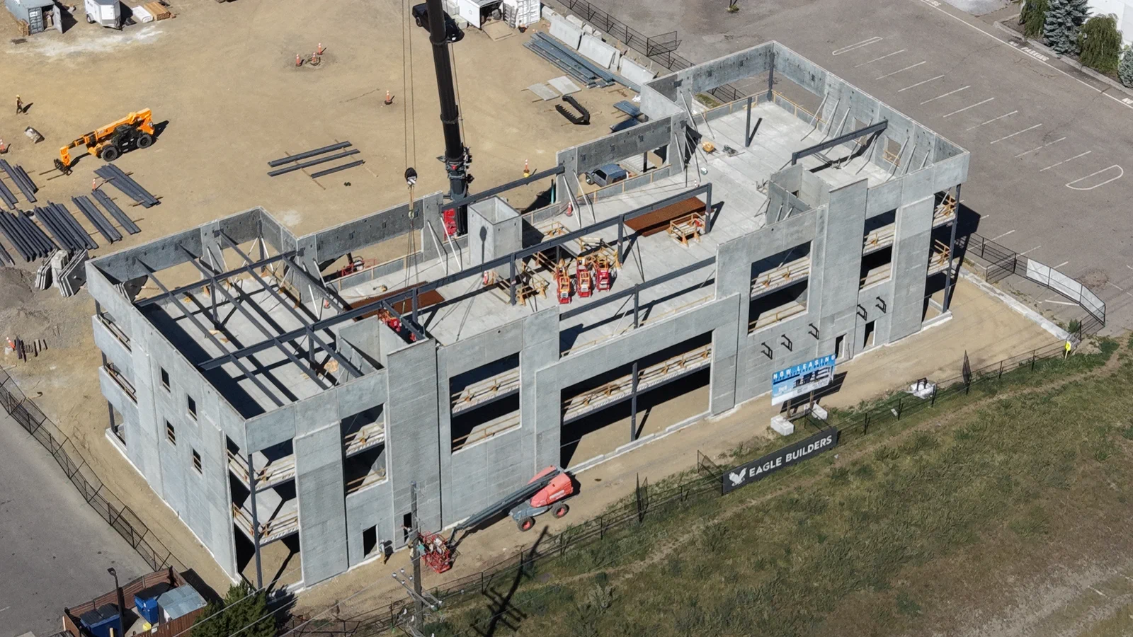 Closer aerial view of RECPLACE Professional Centre's concrete three-storey structure and roof framing